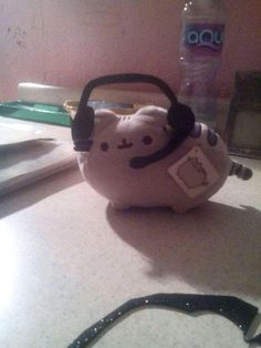 a stuffed animal with headphones sitting on top of a counter next to a pair of glasses