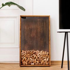 a pile of wine corks sitting in front of a flat screen tv on top of a hard wood floor