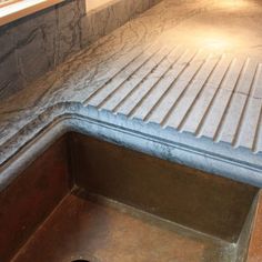 an empty sink in a kitchen with marble counter tops and flooring on the walls