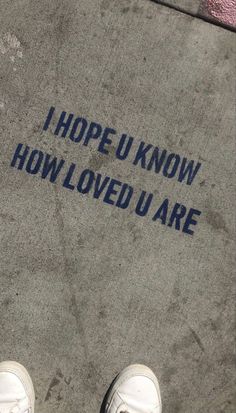 someone is standing on the sidewalk with their feet in the ground and there is a sign that says, i hope u know how loved u are