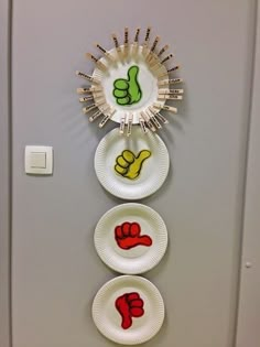 three plates with thumbs up and down painted on them are hanging on the wall next to each other