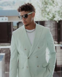 a man in a light green suit and sunglasses