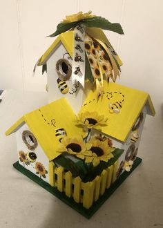 a birdhouse with sunflowers and bees painted on it