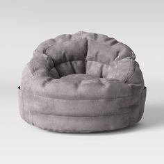 a grey bean bag chair sitting on top of a white floor