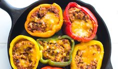 peppers stuffed with ground beef and cheese in a cast iron skillet