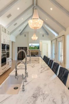 a large kitchen with marble counter tops and an island in front of the stove top