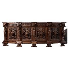 an ornately carved wooden sideboard with four doors and three pedestals on each side