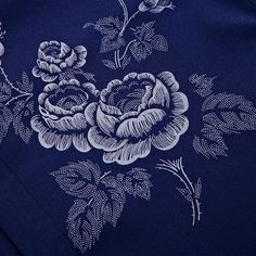 a blue shirt with white flowers on the front and back, is shown in close up