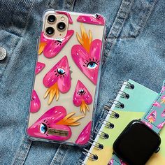 an iphone case with pink flowers on it next to a notepad and notebooks