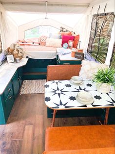 the inside of a camper with tables, chairs and couches in it's interior