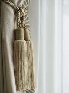 two tassels hanging from the side of a curtain