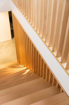 the stairs are made of wood and have white railings