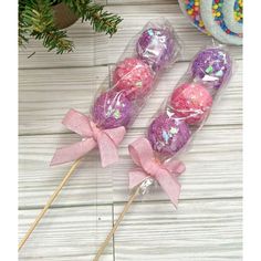 two lollipops wrapped in plastic and tied with pink ribbon