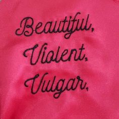 a pink jacket with black writing on it that says beautiful, violent, vulcanar