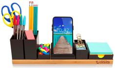 a cell phone sitting on top of a desk next to some pens and pencils