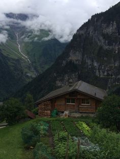 a small cabin in the middle of a lush green valley