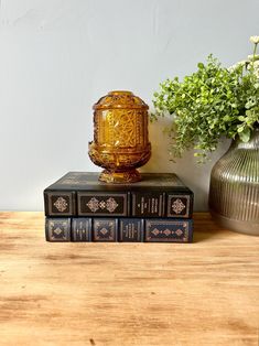 three books sitting on top of each other next to a vase with flowers in it