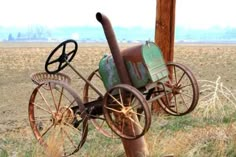 an old rusty bicycle is attached to a pole in the middle of a grassy field