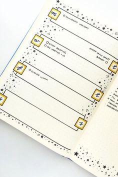 an open planner book with yellow squares and stars on the pages, sitting on a white surface