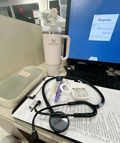 a laptop computer sitting on top of a desk next to a stethoscope