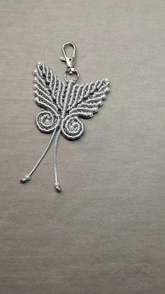 a metal keychain with a leaf design on it