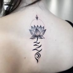 a woman's back with a lotus tattoo on it