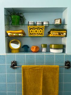 Mid century tiled blue bathroom with vintage accessories from the 60s and 70s. Gold and avocado green accents.