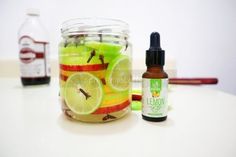 a glass jar filled with sliced apples and limes next to a bottle of lemonade