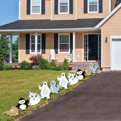 halloween yard decorations in front of a house with ghost's on the side walk