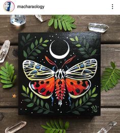 a painting of a butterfly on a black background with leaves and moon in the middle