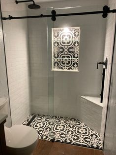 a white toilet sitting in a bathroom next to a walk in shower and tiled floor