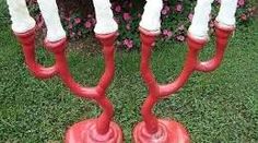 a red and white candelabra with candles on it sitting in the grass