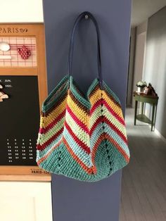 a crocheted bag hanging on the wall