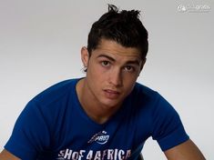 a young man in a blue shirt posing for a photo