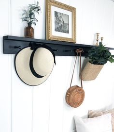 two hats are hanging on the wall with hooks and plants in baskets next to them