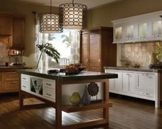 a large kitchen with wooden floors and white cupboards on the walls, along with an island in the middle