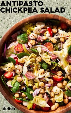 an image of a salad with chickpea and spinach in a wooden bowl