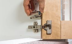 a person is opening a cabinet door with two latches on the front and side