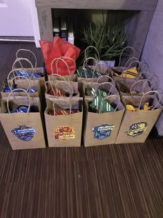 several brown paper bags sitting on the floor next to each other with stickers on them