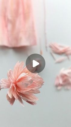 a pink flower sitting on top of a table