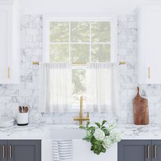 a kitchen with marble counter tops and white cabinets, along with a window over the sink