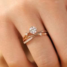 a woman's hand with a diamond ring on top of her finger and the other hand holding an engagement ring