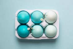 blue and white eggs in an egg carton on a blue background - stock photo - images