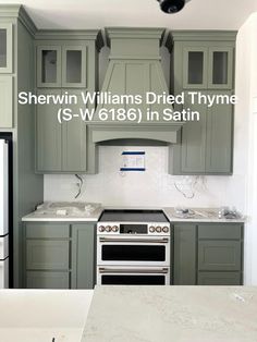 a kitchen with gray cabinets and white counter tops, including an oven in the center