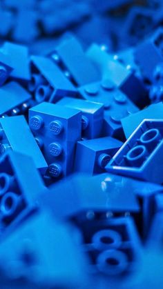 many blue legos are scattered together in the dark, and they look like they have numbers on them