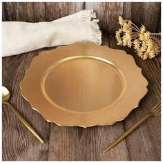 an empty gold plate on a wooden table