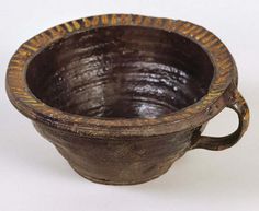 an old brown bowl with handles on a white background