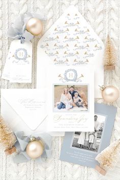 the wedding stationery is laid out on a white blanket with gold and silver ornaments