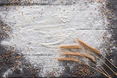 wheat seeds and flour on a wooden background with space for text or image top view