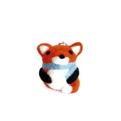 an orange and white stuffed animal with a blue scarf around it's neck on a white surface